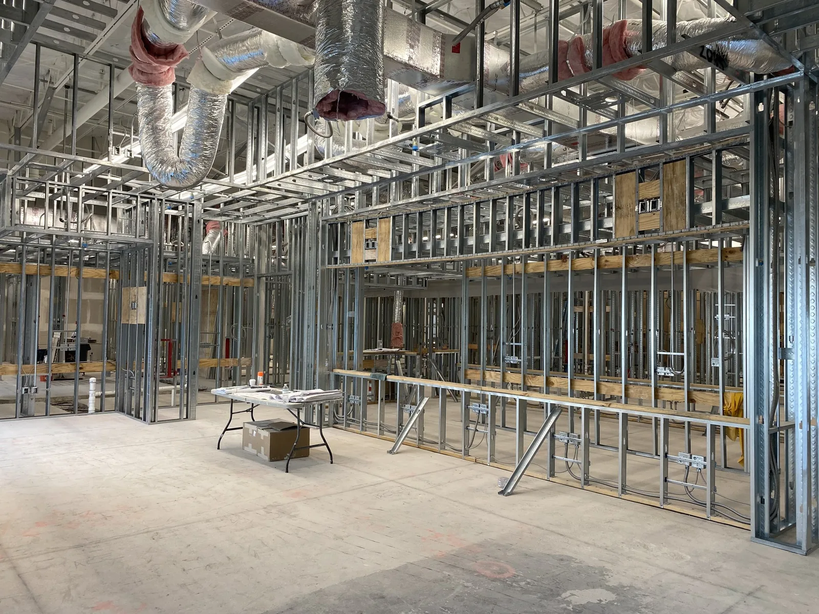 Interior framing with metal studs, drywall, and HVAC ductwork — commercial fit-out.