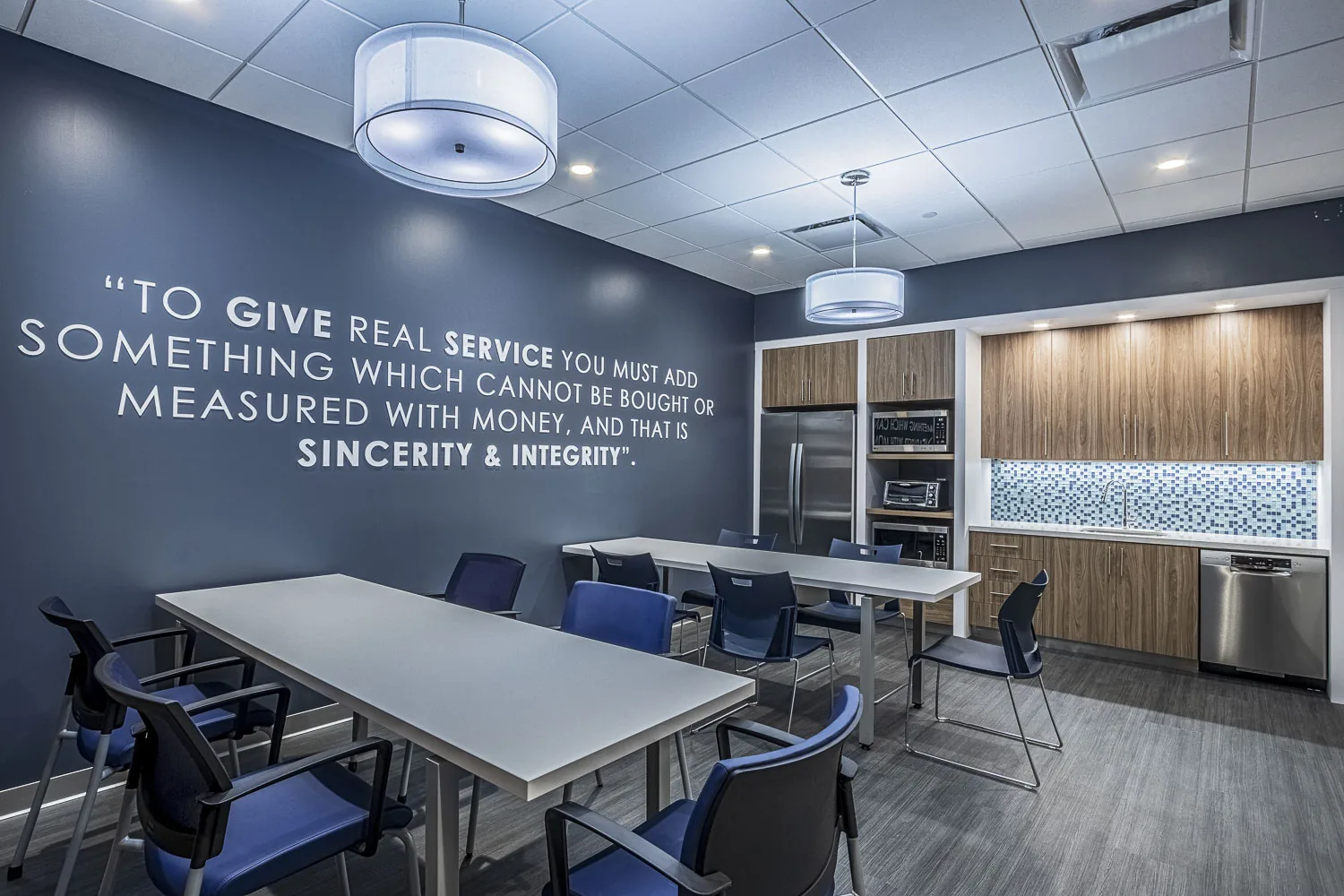 Office break room with motivational wall quote and modular seating.
