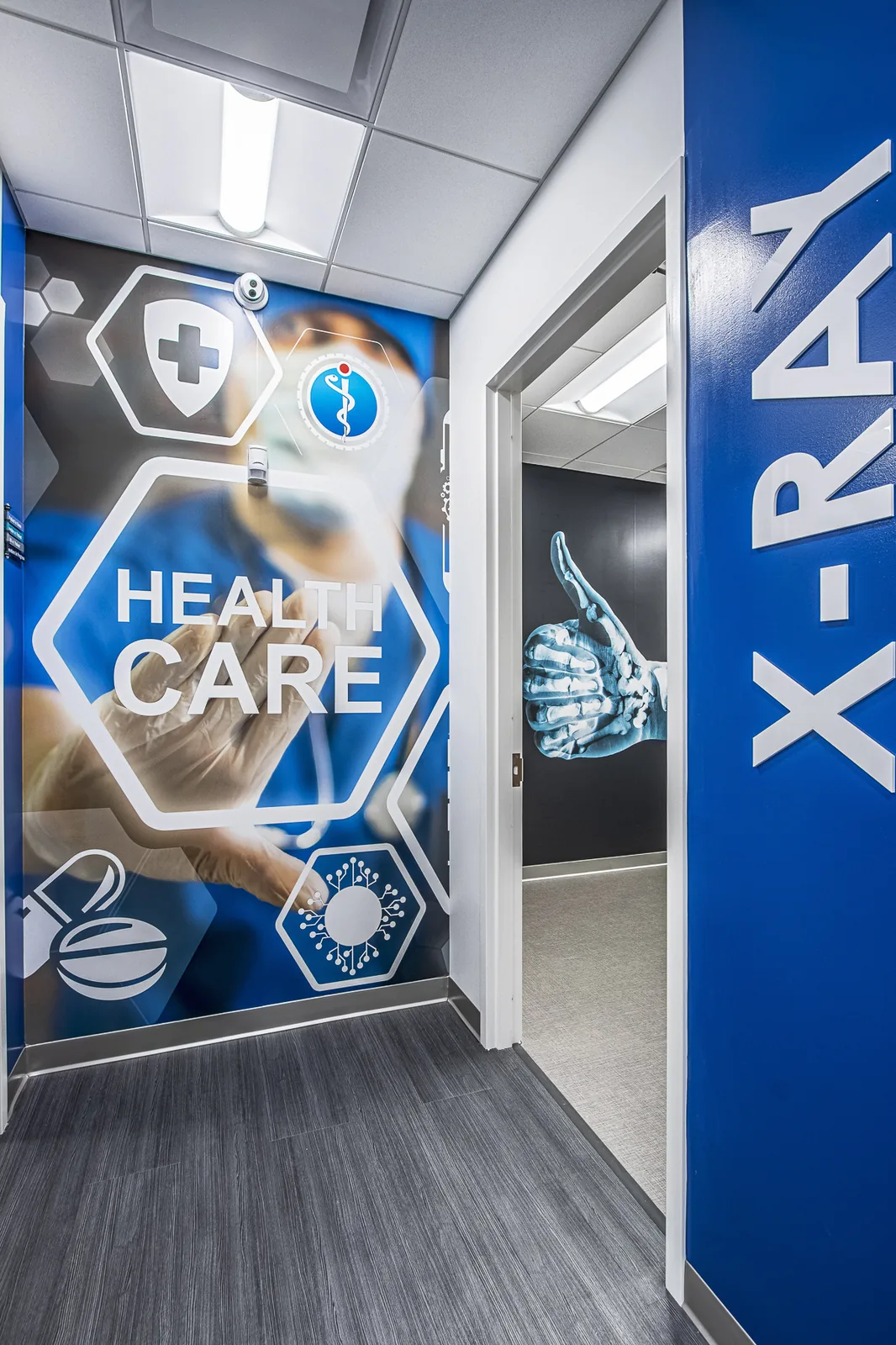 Medical office hallway with healthcare branding and blue geometric wall graphics.