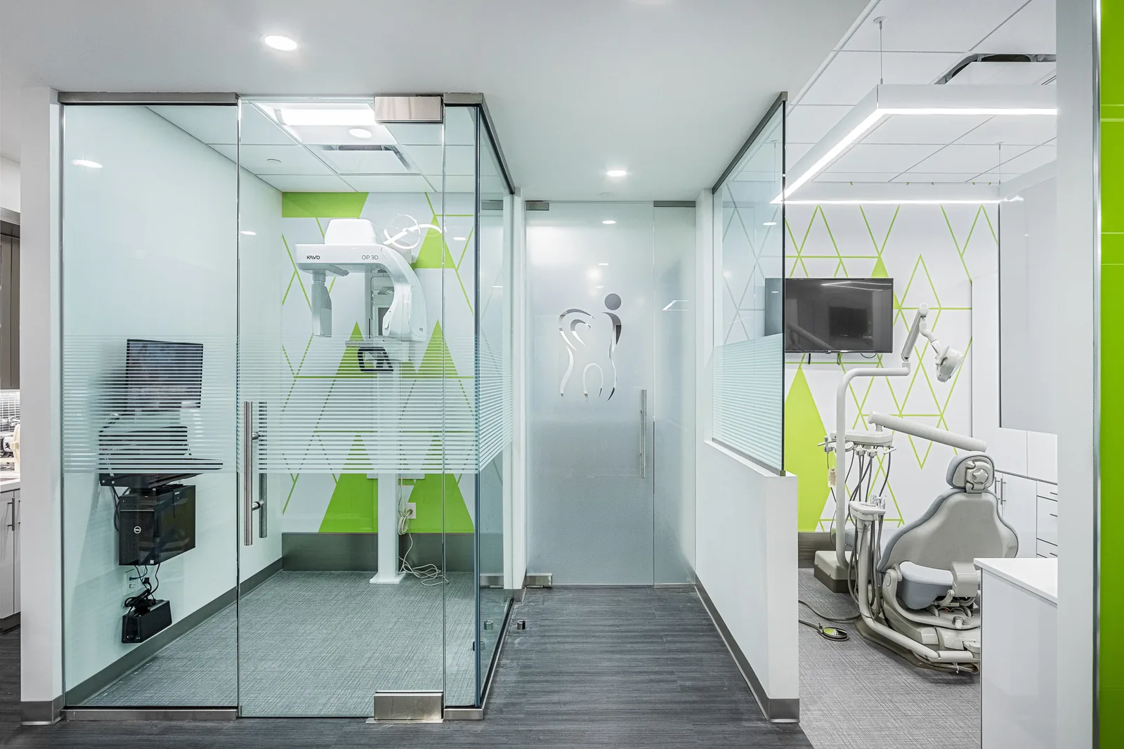 Dental office with glass-partitioned treatment rooms and lime green accents.